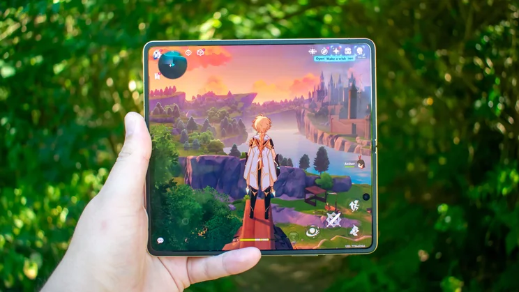 Honor Magic V6 unfolded in hand, mobile game on the display