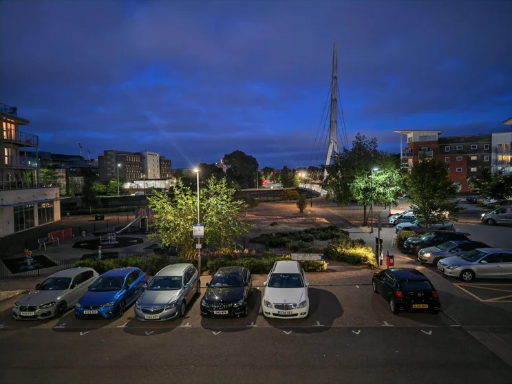 A car park at night with buildings on both sides
