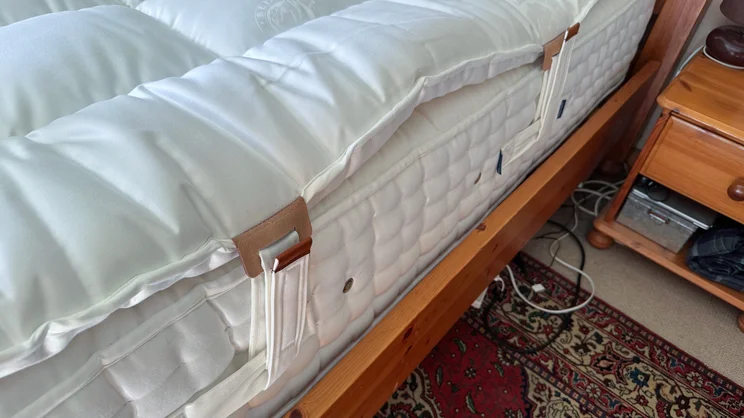 A closeup of the side of the Hypnos Inspired By Nature Wool and Latex Enhancer, attached to a mattress by its handles
