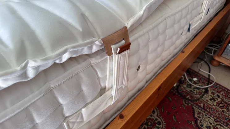 A closeup of the side of the Hypnos Inspired By Nature Wool and Latex Enhancer, attached to a mattress by its handles