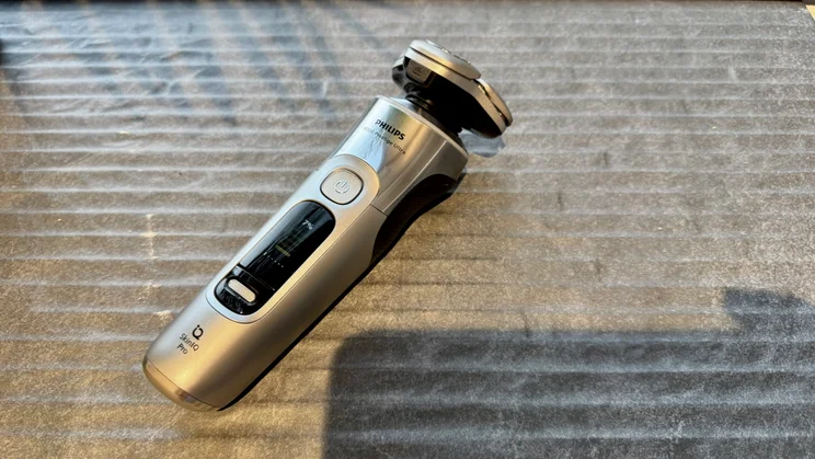 Philips i9000 Prestige Ultra - wide shot of shaver lying on linen