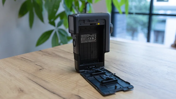 The Instax Mini Evo Cinema on a table in an office. The empty film compartment is open