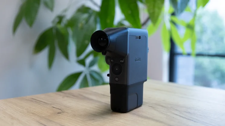 The Instax Mini Evo Cinema, with viewfinder attachment, on a table in an office