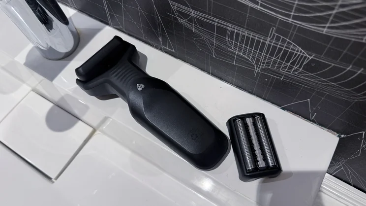 The Manscaped Chairman Plus electric shaver, with precision tool attached, alongside the foil head on the side of a sink