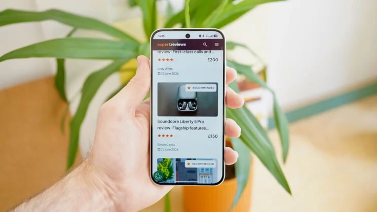 Oppo Reno 16 Pro in hand, displaying Expert Reviews homepage