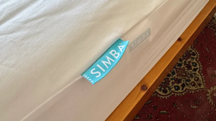 A closeup of the side of the Simba TripleShield Bamboo mattress protector, with the Simba logo label