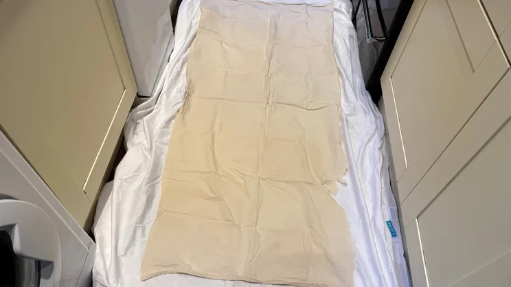 The Simba TripleShield Bamboo mattress protector on a kitchen floor, sandwiched between two pieces of bedsheet