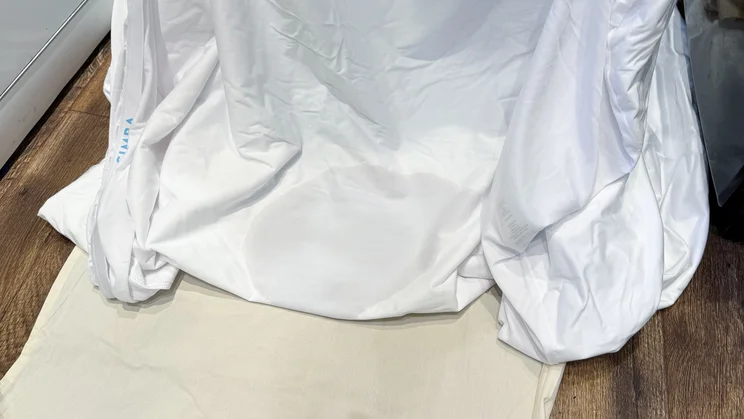 The Simba TripleShield Bamboo mattress protector being lifted off a sheet, during spill tests
