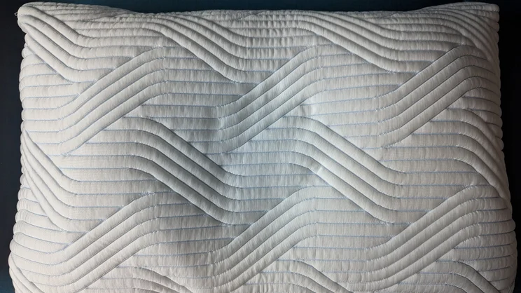 A bird's eye view of the Tempur Cloud SmartCool pillow. An imprint is left in its surface from where a hand was pressing down on the pillow