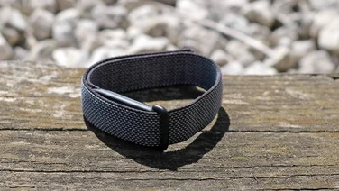 The Fitbit Air pictured on a wood surface