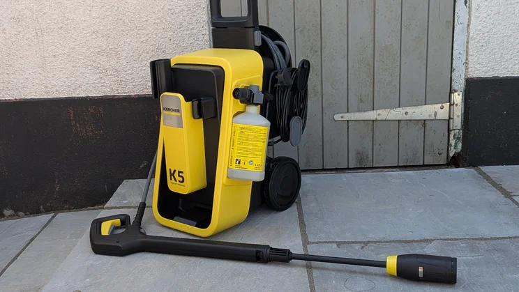 The Karcher K5 Comfort Premium pictured on patio flagstones, in front of a grey wood door