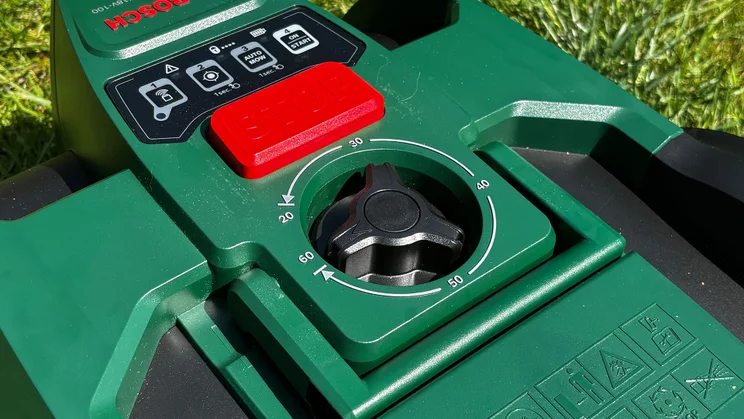 The Bosch VISIMOW18V-100's top panel, showing its hight adjustment dial and emergency stop button