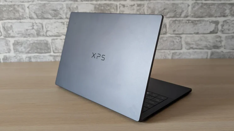 Rear view of the new Dell XPS 14 laptop on a wooden table with its lid open
