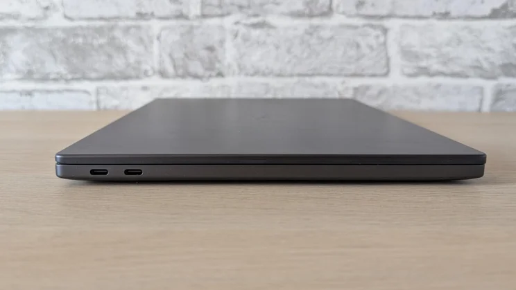 Side view of the new Dell XPS 14 laptop on a wooden table with its lid closed
