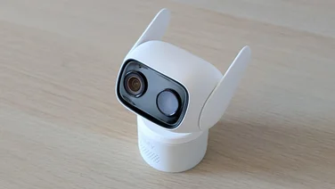 The Eufy Wired Cam C1 security camera on a wooden table with its antennae up