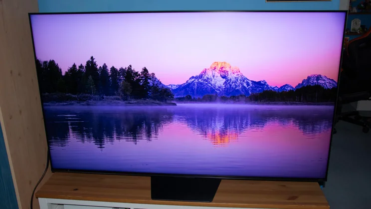 The Hisense UR8S RGB Mini LED TV displaying an image of a mountain and a lake in Dynamic Mode