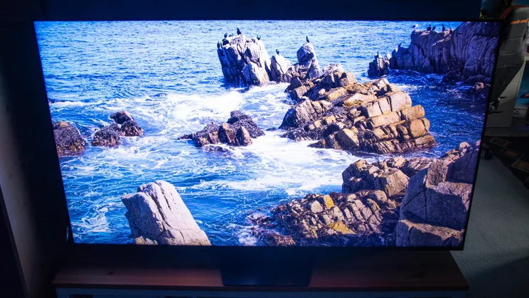 The Hisense UR8S RGB Mini LED TV displaying an image of a rocky coastline in Dynamic Mode
