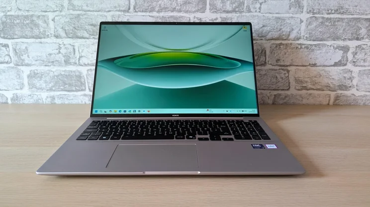 Front view of the Honor MagicBook 16 laptop on a wooden table with its lid open