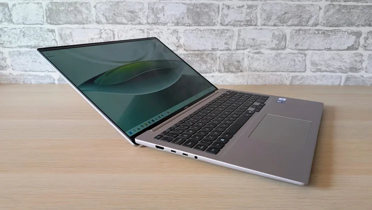 Side view of the Honor MagicBook 16 laptop on a wooden table with its lid open