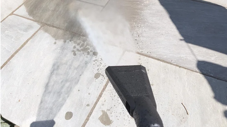 The K&auml;rcher K3 eco!Booster pressure washer's flat-jet nozzle spraying water onto a patio