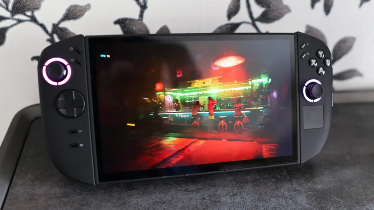 Left view of the Lenovo Legion Go 2 PC gaming handheld on its stand displaying a bar scene from Cyberpunk 2077