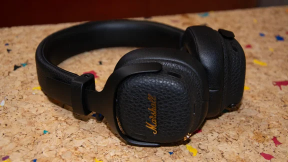 The Marshall Milton ANC on-ear headphones lying sidewards on a cork table