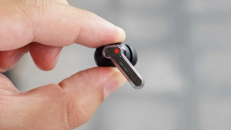 A single Nothing Ear (3a) wireless earbud being held with its stem facing outwards