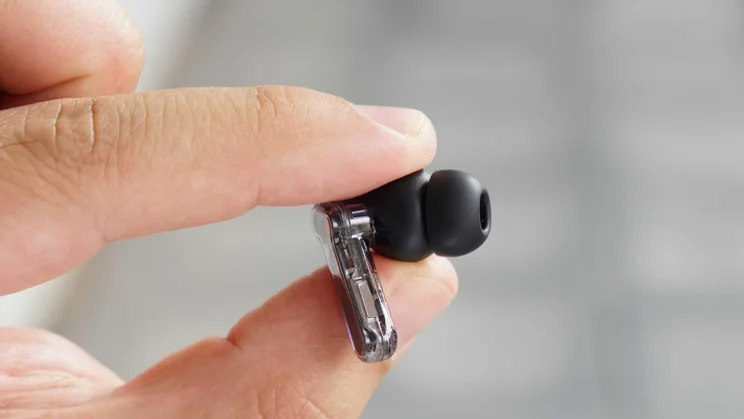 A single Nothing Ear (3a) wireless earbud being held with its eartip facing outwards