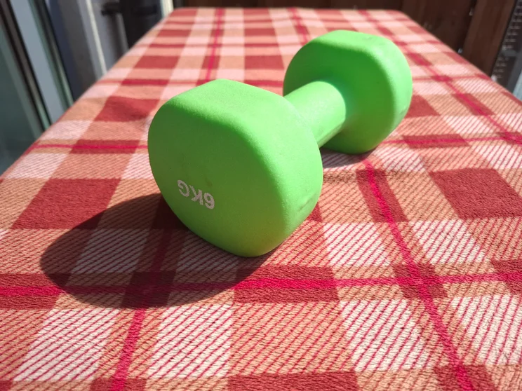A green dumbbell on a red tablecloth