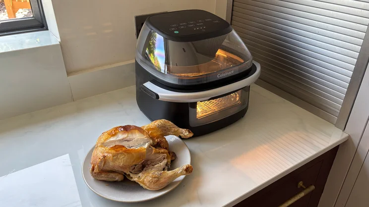 The Cuisinart Clearview 9-in-1 air fryer on a kitchen worktop, alongside a cooked chicken