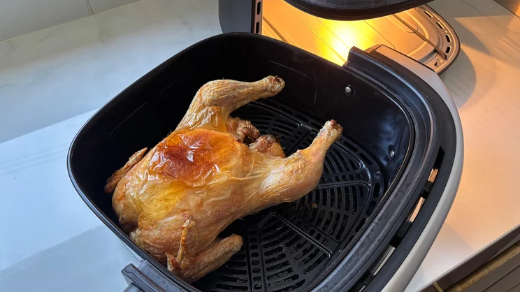 A cooked chicken inside the open drawer of the Cuisinart Clearview 9-in-1 air fryer