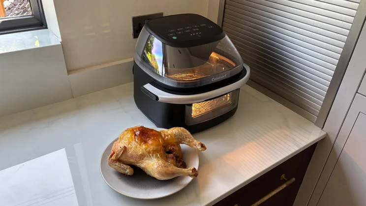 The Cuisinart Clearview 9-in-1 air fryer on a kitchen worktop, alongside a cooked chicken