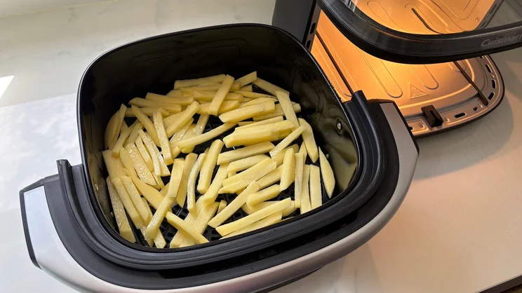 A bird's eye view of raw chips in the Cuisinart Clearview 9-in-1 air fryer's open drawer
