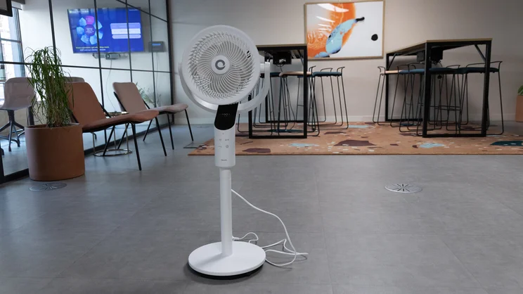 The Devola 8in Low Noise DC Pedestal fan on the floor of an office