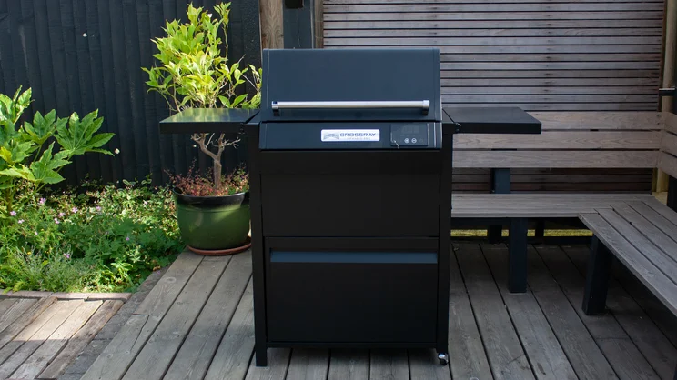 The Dimplex Crossray eXtreme BBQ on its stand, on wooden decking
