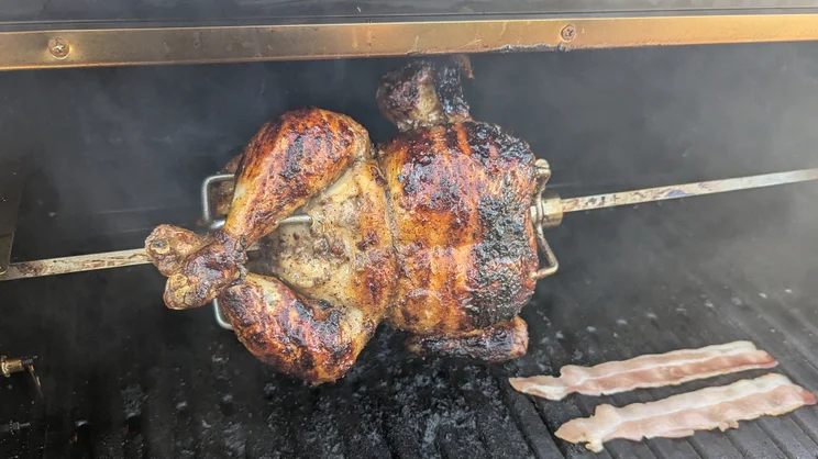 A chicken cooking on the Dimplex Crossray eXtreme BBQ rotisserie attachment