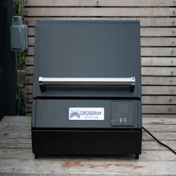 The Dimplex Crossray eXtreme BBQ, without its stand, on a wooden bench