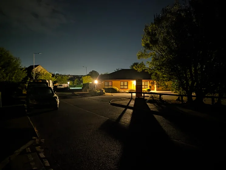 A quiet street at night with lights outside one building