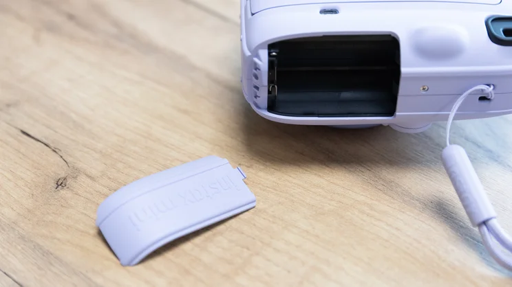 The Instax Mini 13 instant camera's open battery compartment