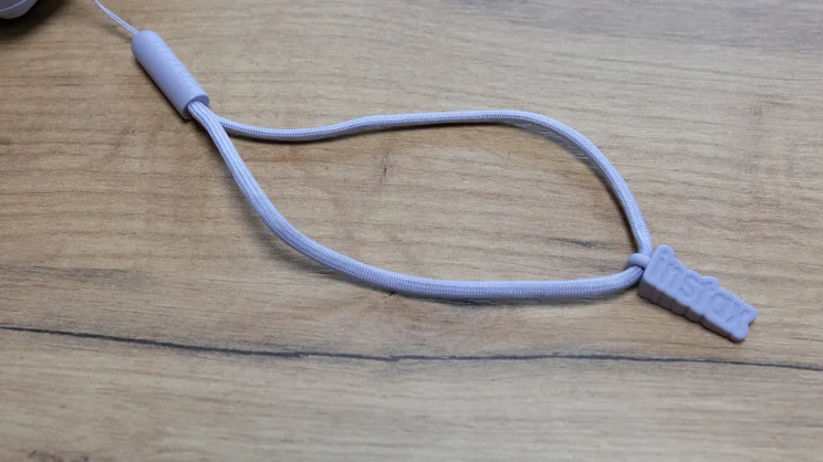 The Instax Mini 13 instant camera's hand strap, on an office table