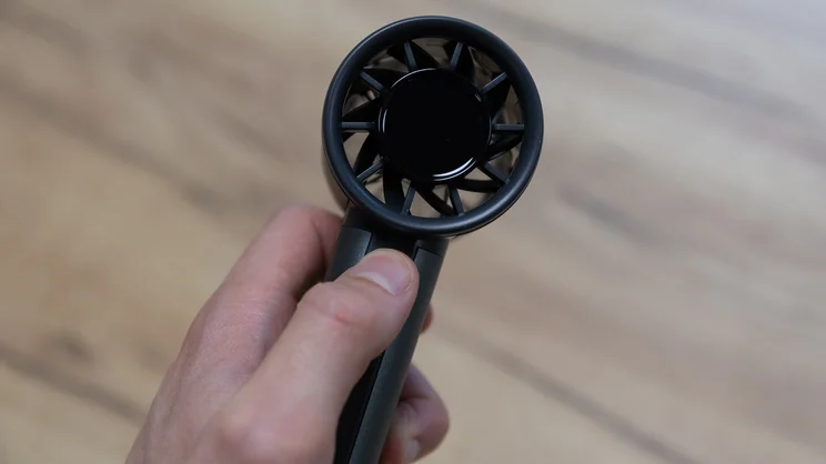 A closeup of the John Lewis High Power Handheld Fan, held in the hand