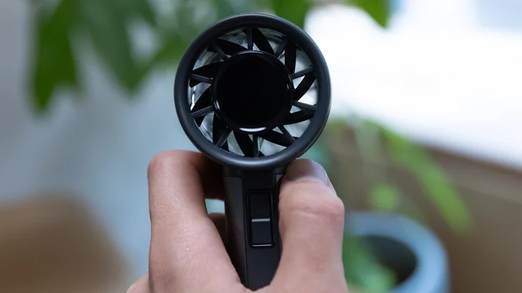 A closeup of the John Lewis High Power Handheld Fan, held in the hand