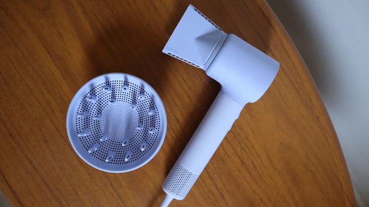 A bird's eye view of the Laifen Neo hair dryer, with its concentrator nozzle attached, alongside its diffuser attachment