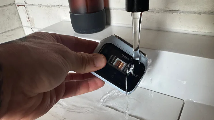 The Laifen P3 shaver being washed under a running tap in a bathroom sink