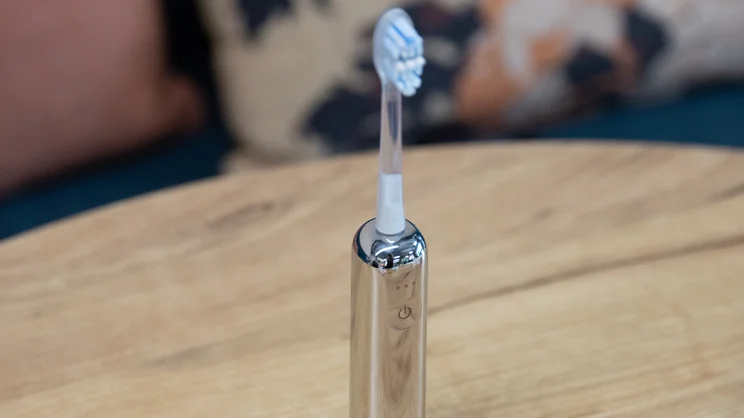 The Laifen Wave Pro electric toothbrush standing upright on a table, with its Plaque Removal head attached