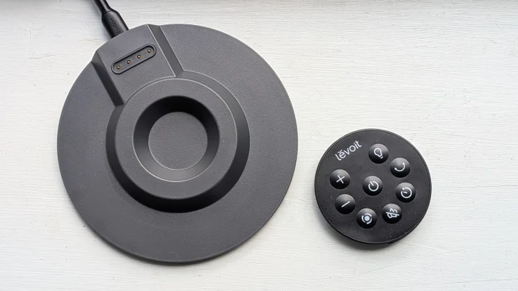 A bird's eye view of the Levoit Windi Mini Pro fan's charging base and remote control