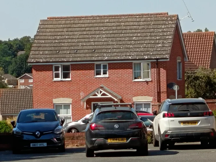 10x digital zoom of a red house with cars parked out front