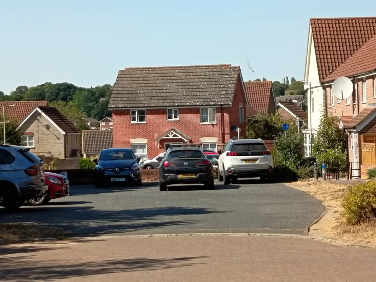 5x digital zoom of houses with cars parked out front