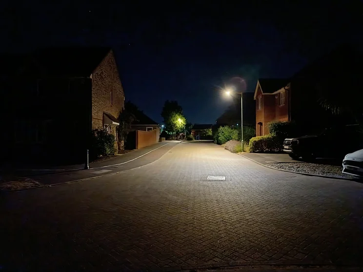 A quiet street at night, lit by streetlamps