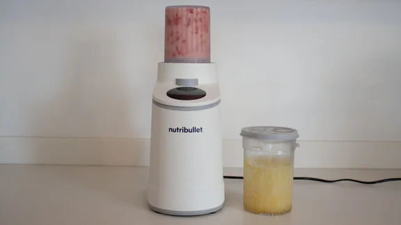 The Nutribullet Chill ice cream maker on a kitchen counter, next to a tub of lemon sorbet